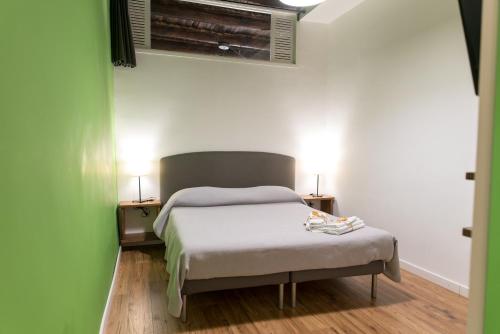 un letto in una camera con due comodini e due lampade di Sleep & Zupp Casa Olimpia a Napoli