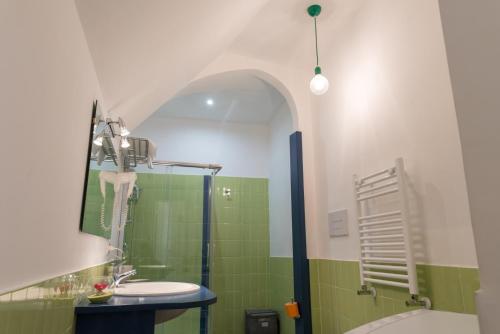 bagno con lavandino e doccia con piastrelle verdi di Sleep & Zupp Casa Olimpia a Napoli