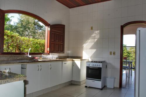 a kitchen with a stove and a window in it at Pousada Cachoeira Poço Encantado in Alto Paraíso de Goiás
