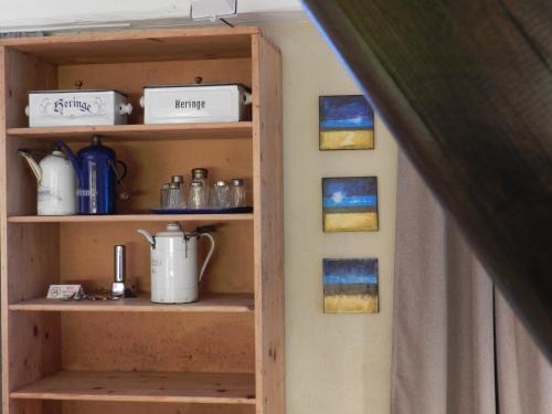 a shelf in a room with paintings on the wall at Blue Wall BnB in Gebenstorf