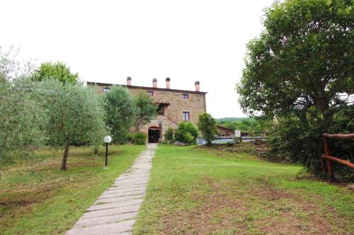 a walkway in front of a large brick building at Casale Aiola in Poggioni