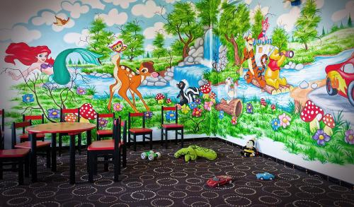 uma sala de jantar com um mural de disney na parede em Domeniul Dornei em Vatra Dornei