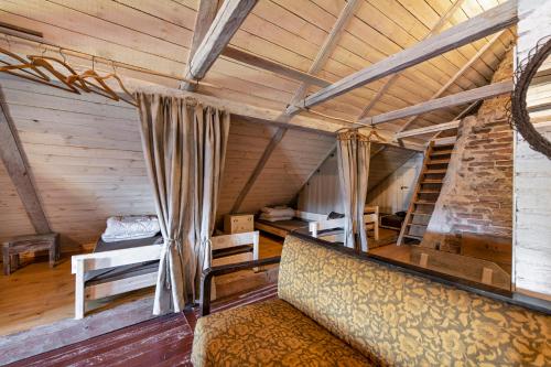 an attic room with a bed and a couch at Pagulbis - Tavo namai in Klabiniai