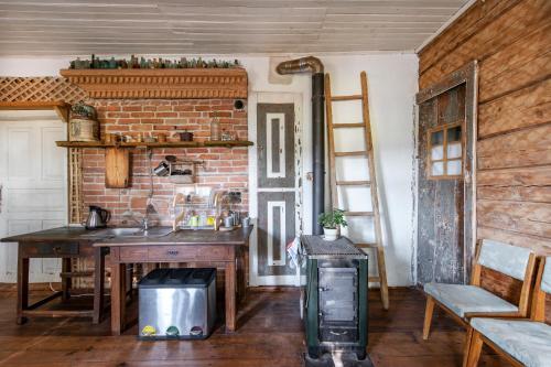 a kitchen with a sink and a brick wall at Pagulbis - Tavo namai in Klabiniai