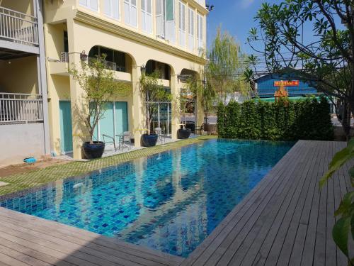 a swimming pool in front of a building at Latima Boutique Hostel in Kanchanaburi City