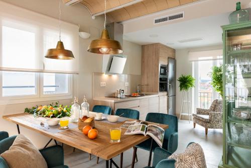 een keuken en eetkamer met een houten tafel en stoelen bij Genteel Home Carmen San Ignacio in Granada