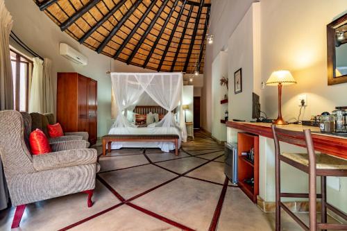 a living room with a bed and a couch at Blue Jay Lodge in Hazyview