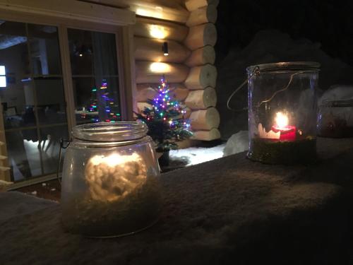 a christmasmas tree in a room with candles and a mason jar at Chalet Karin in Hochfilzen