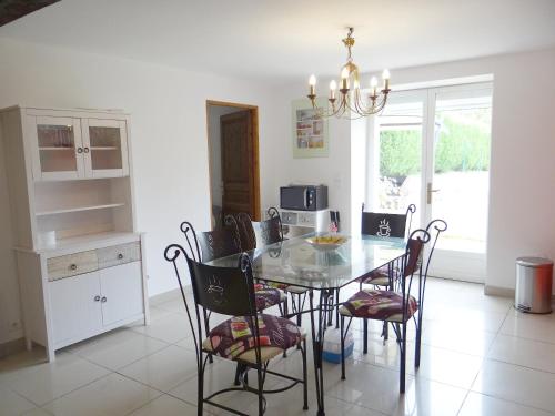 une salle à manger avec une table et des chaises en verre dans l'établissement Gîte L'étable, à Dole