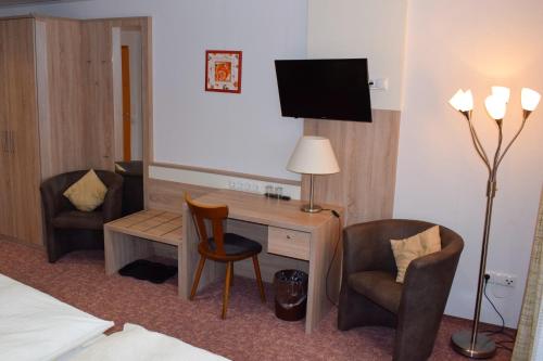 a hotel room with a desk and two chairs at Pension Ethner in Bad Driburg