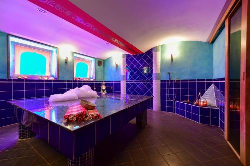 ein blaues Badezimmer mit einer Badewanne mit violetter Beleuchtung in der Unterkunft Christinenhof & Spa - Wellnesshotel am Rande des Spreewalds in Tauer