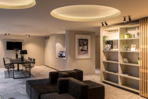 a living room with a table and a couch and chairs at PREMIER SUITES Antwerp in Antwerp