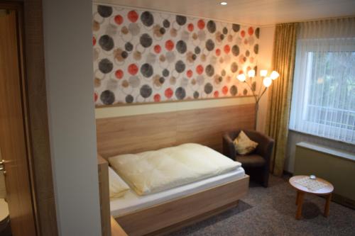 1 dormitorio pequeño con 1 cama y 1 silla en Pension Ethner, en Bad Driburg