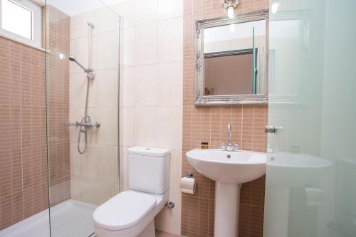 a bathroom with a toilet and a sink and a shower at Evita in Faliraki