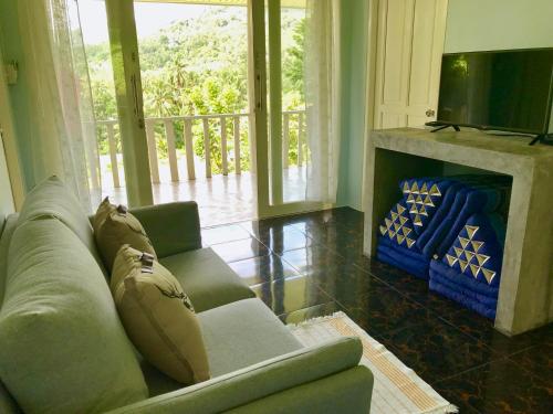 a living room with a couch and a fireplace at Kiri Tawan in Baan Tai