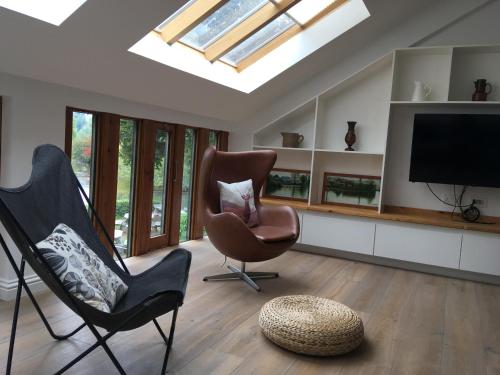 a living room with two chairs and a flat screen tv at Bakewell Riverview in Bakewell