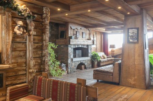 a living room with a stone fireplace and a couch at Résidence Pierre & Vacances Premium Les Alpages de Reberty in Les Menuires