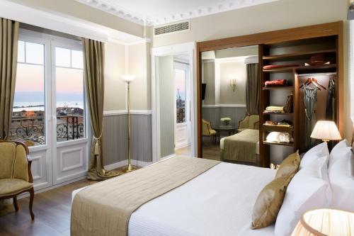 a hotel room with a bed and a balcony at Mediterranean Palace in Thessaloniki