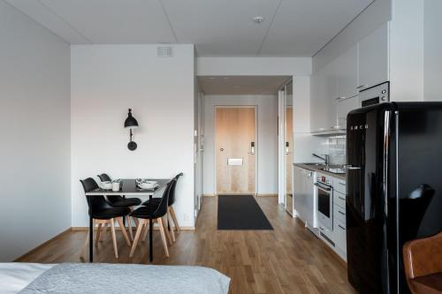 een keuken en eetkamer met een tafel en stoelen bij Apartment Station in Oulu