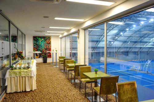 une salle à manger avec des tables et des chaises ainsi qu'un court de tennis dans l'établissement Hotel EMPIRE, à Trnava