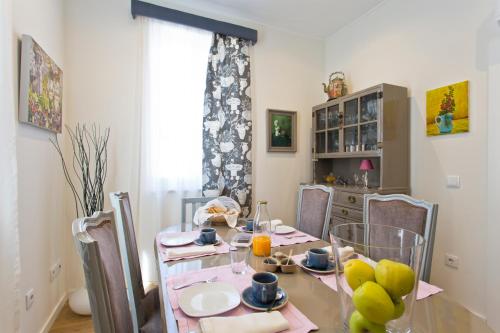een eetkamer met een tafel en stoelen met fruit erop bij Luxurious Pink House and Parking in Porto