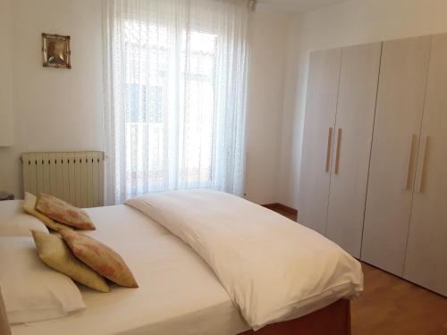 a bedroom with a bed with white sheets and a window at Casa MIA in Venice