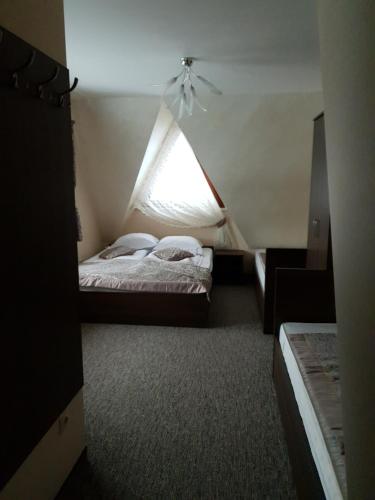 a small room with two beds and a window at Ostrysz in Dzianisz