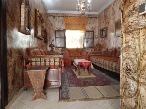 sala de estar con muebles y lámpara de araña. en Marguerite Apartemnt dans une résidence familiale, en Casablanca