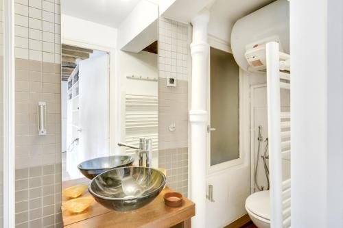 - une salle de bains avec deux lavabos sur un comptoir en bois dans l'établissement Saint Germain des Près UNIT 002, à Paris