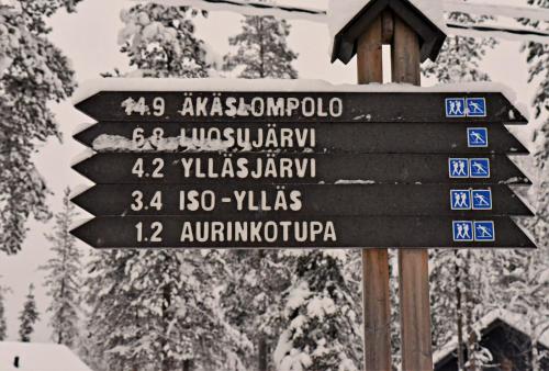 a street sign with directions to different countries at Hotel Ylläsrinne in Ylläsjärvi