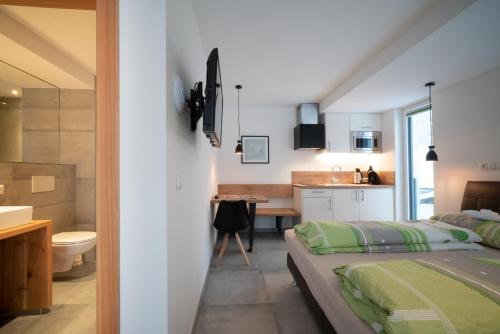 a bedroom with a bed and a bathroom with a sink at Stadlchalet in Ried im Oberinntal