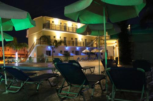 a group of chairs and umbrellas in front of a building at La caretta in Alikanas
