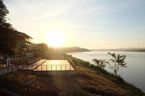 a view of a river with the sun setting at Baan Kokaew Chiang Khan in Chiang Khan