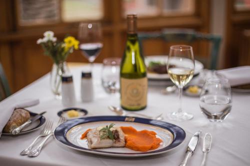 a table with a plate of food and a bottle of wine at Hotel Casa Real - Viña Santa Rita in Santiago