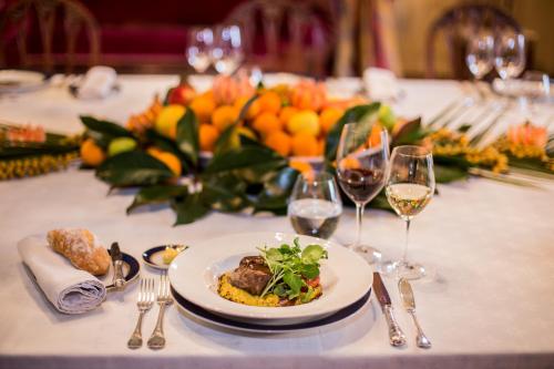 a table with a plate of food and glasses of wine at Hotel Casa Real - Viña Santa Rita in Santiago