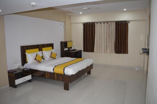 a bedroom with a large bed with yellow pillows at Dhuri Resort in Vasai