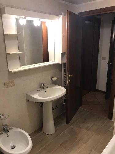 a bathroom with a sink and a mirror and a toilet at Casa Cortese in Gallio