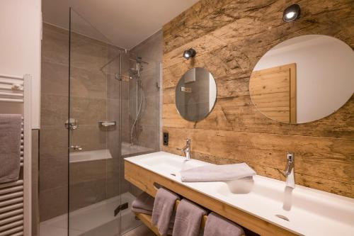 ein Bad mit einem Waschbecken und einem Spiegel in der Unterkunft Drittlhof in Hopfgarten im Brixental