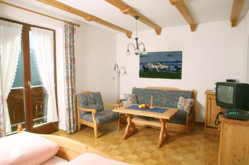 a living room with a couch and a table and a tv at Gästehaus Ortner in Liesing