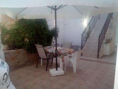a table and chairs under an umbrella on a patio at Nikos and Eva Studios in Symi