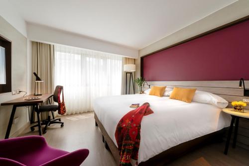 1 dormitorio con 1 cama blanca grande y pared roja en Mercure Ariosto Lima, en Lima