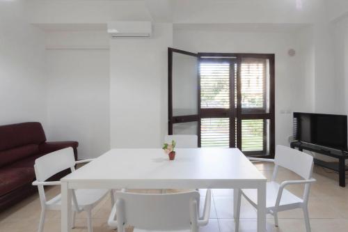 a white table and chairs in a living room at Apartments d'Orlando - 2 bedrooms apartment with garden in Capo dʼOrlando