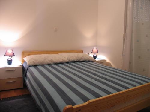 1 dormitorio con 1 cama con 2 lámparas en 2 mesitas de noche en Apartments Sanmar, en Mandre