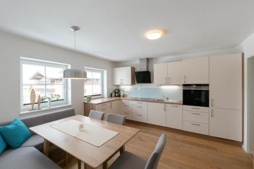 a kitchen and dining room with a wooden table at Wawies Apartments in Flachau