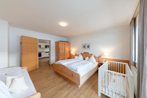 a bedroom with two beds and a crib in it at Wawies Apartments in Flachau