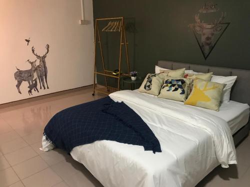 a bedroom with a large bed with many pillows at The Alley's @ Sitiawan, Manjung in Sitiawan