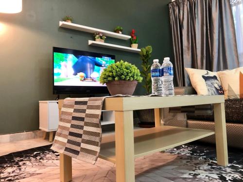 a living room with a table and two bottles of water at The Alley's @ Sitiawan, Manjung in Sitiawan