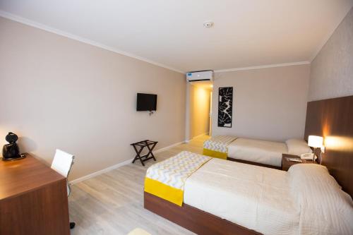 a hotel room with two beds and a desk at Platinum Hotel Casino in Villa Ángela
