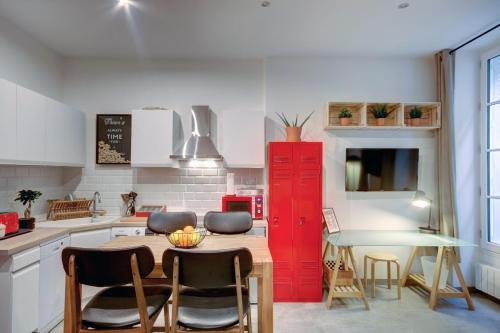 une cuisine avec une armoire rouge et une table dans l'établissement LE COCOON 29 by Cocoonr, à Bordeaux