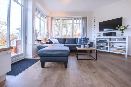 a living room with a couch and a tv at Dünenstern in Wangerooge